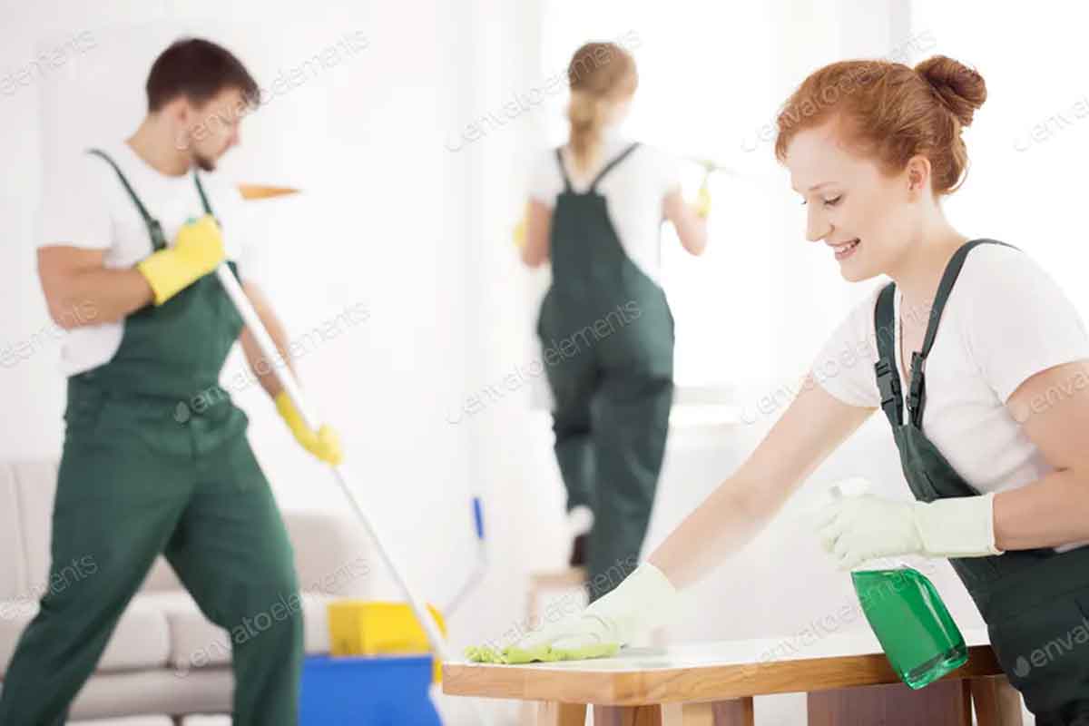 a man and two women cleaning an office